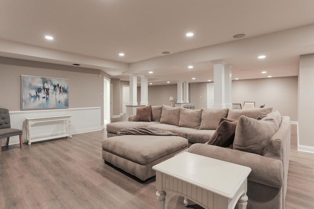 living room featuring decorative columns and light wood-type flooring