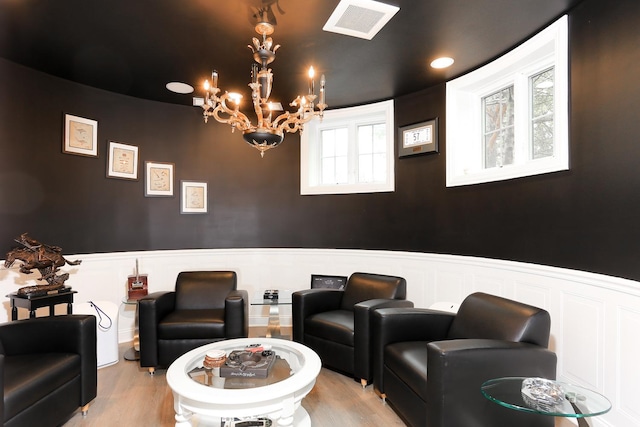 home theater featuring light wood-type flooring and an inviting chandelier