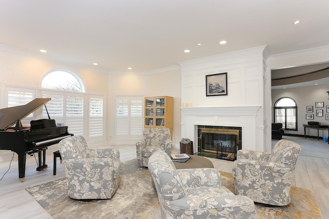 living room featuring a fireplace, ornamental molding, and light wood-type flooring