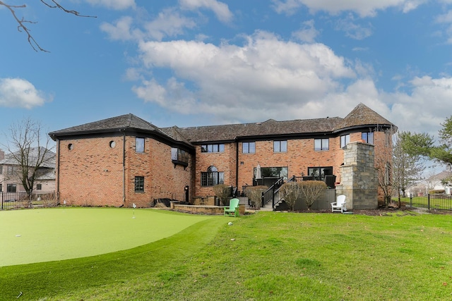 rear view of house featuring a lawn