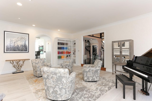 living room with ornamental molding and light hardwood / wood-style flooring