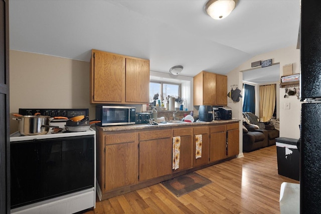 kitchen featuring electric stove, vaulted ceiling, and light hardwood / wood-style flooring