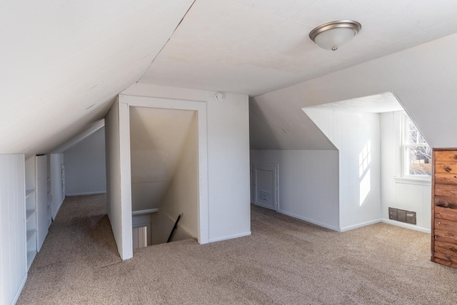 bonus room with lofted ceiling, visible vents, and light carpet