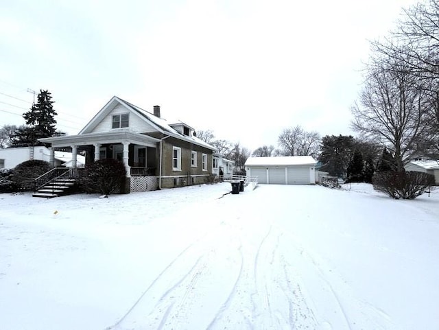 view of front of home featuring a garage, an outdoor structure, and a porch