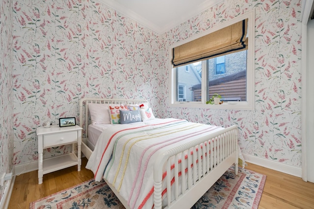 bedroom with wood-type flooring and ornamental molding