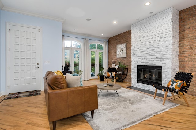 living room featuring crown molding, a fireplace, and light hardwood / wood-style floors