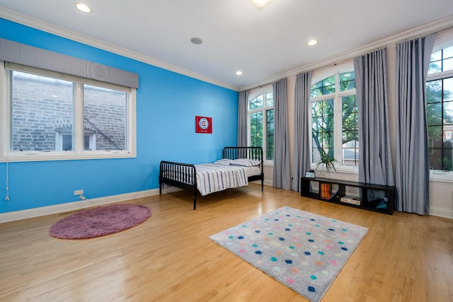 bedroom with multiple windows, crown molding, and wood-type flooring