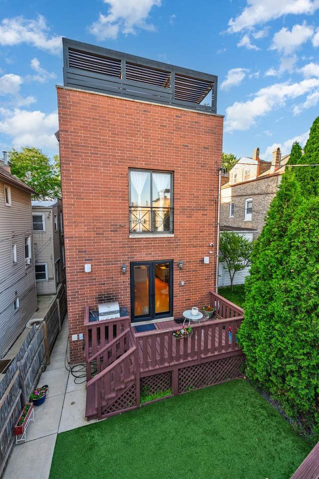 rear view of property with french doors, a yard, and a wooden deck