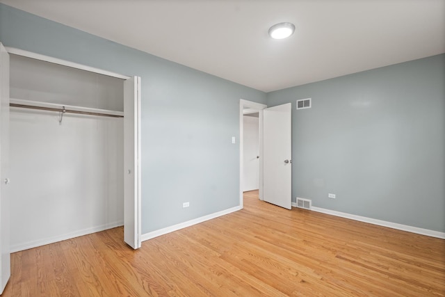 unfurnished bedroom with light hardwood / wood-style flooring and a closet