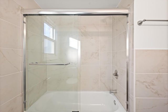 bathroom with shower / bath combination with glass door