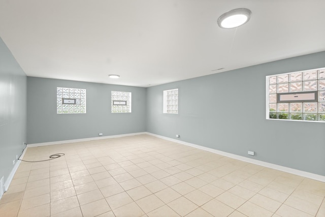 spare room featuring plenty of natural light and light tile patterned floors