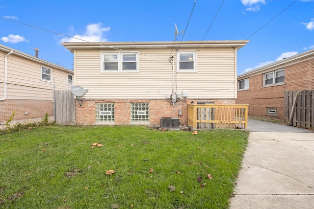 back of house with central AC and a lawn