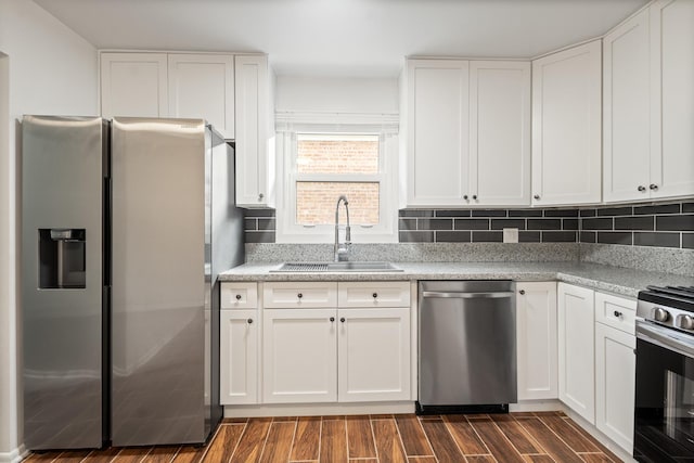 kitchen featuring tasteful backsplash, appliances with stainless steel finishes, sink, and white cabinets