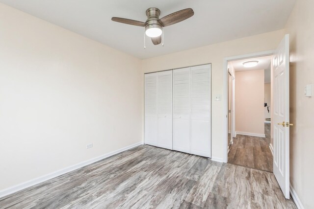 unfurnished bedroom with ceiling fan, a closet, and light wood-type flooring