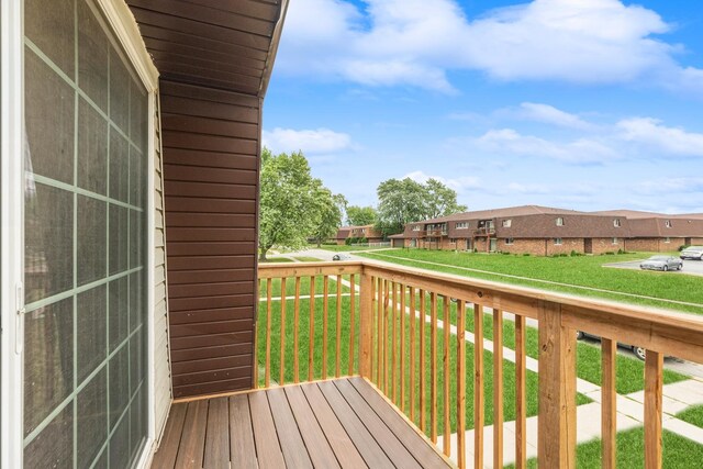 wooden terrace featuring a lawn