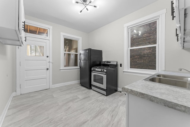 kitchen with black refrigerator, sink, and gas stove