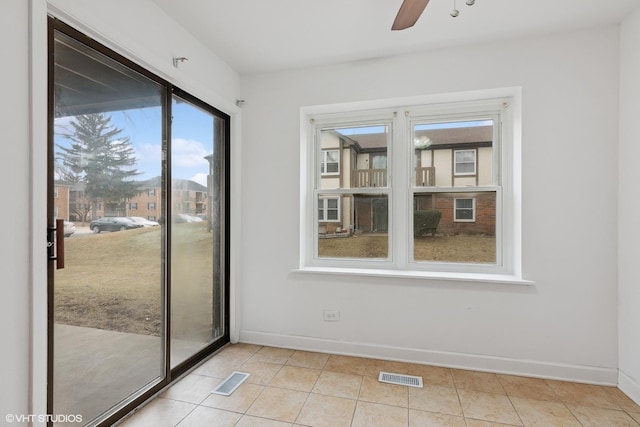 empty room with light tile patterned floors and ceiling fan