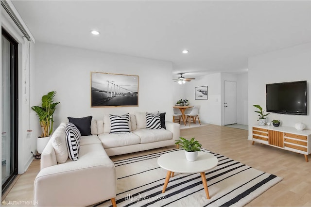 living room featuring ceiling fan and light hardwood / wood-style floors