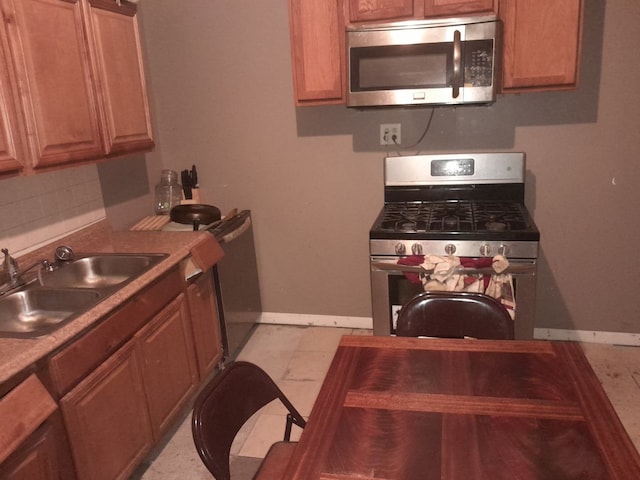 kitchen featuring appliances with stainless steel finishes, sink, and backsplash