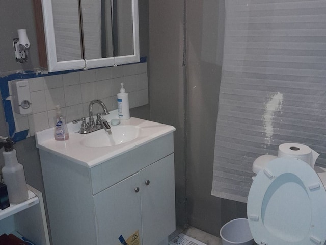 bathroom with vanity, toilet, tile walls, and decorative backsplash