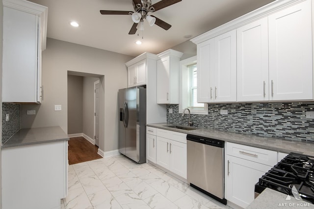 kitchen featuring sink, ceiling fan, stainless steel appliances, tasteful backsplash, and white cabinets