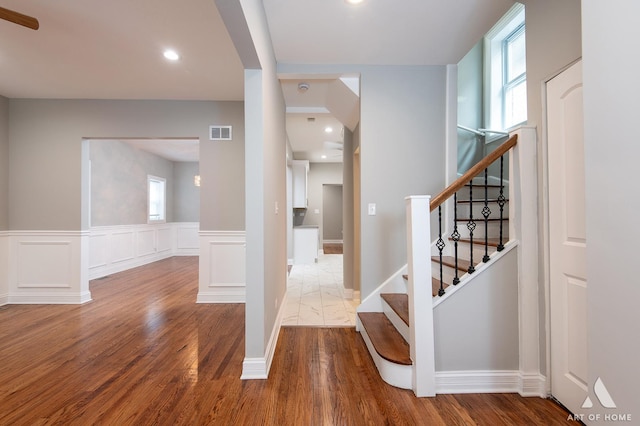 stairs with hardwood / wood-style flooring and plenty of natural light