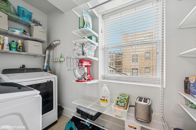 laundry room featuring light tile patterned floors, laundry area, and washer and clothes dryer