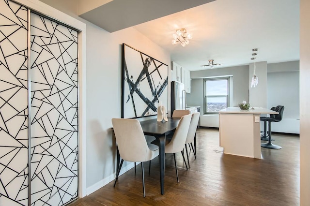 dining space with dark wood-style floors, baseboards, and an inviting chandelier