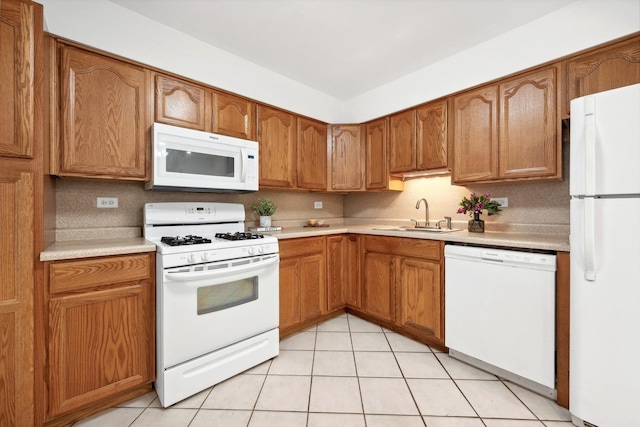 kitchen with sink, light tile patterned floors, and white appliances