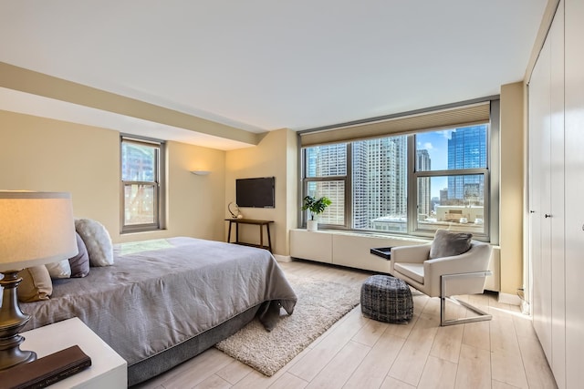 bedroom featuring multiple windows and light hardwood / wood-style floors