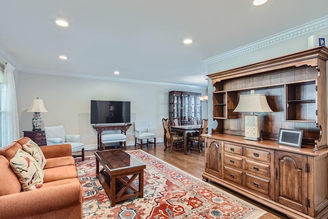 living room with ornamental molding, a notable chandelier, and light wood-type flooring