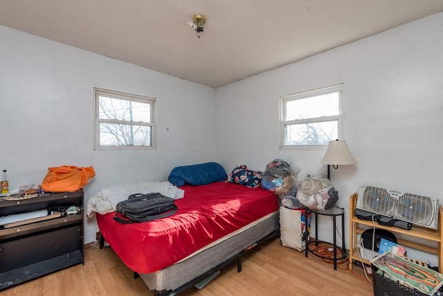 bedroom featuring multiple windows and light hardwood / wood-style flooring