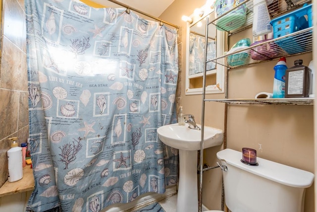 bathroom featuring sink, curtained shower, and toilet