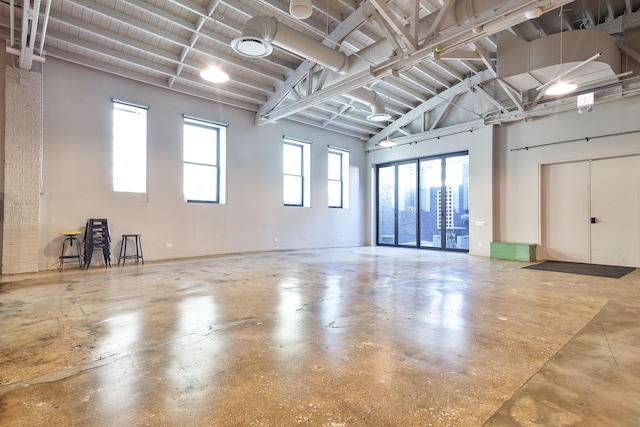 interior space with high vaulted ceiling and concrete flooring