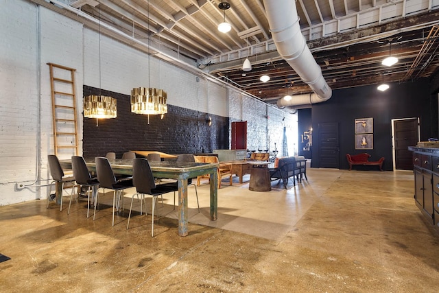 dining room featuring a towering ceiling, concrete flooring, and brick wall