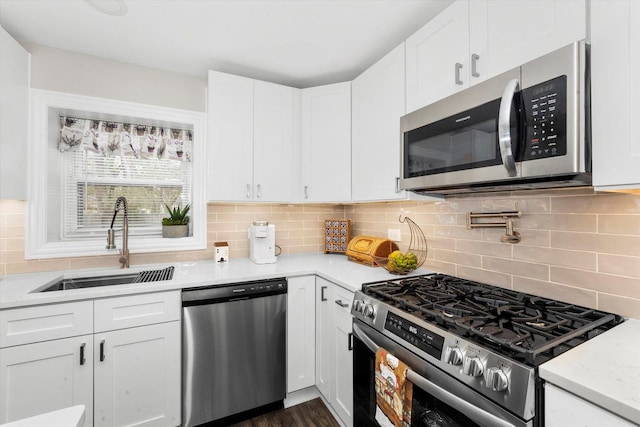 kitchen featuring sink, decorative backsplash, white cabinets, and appliances with stainless steel finishes