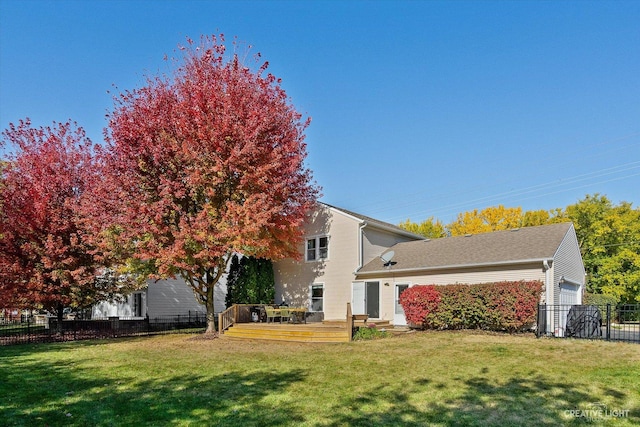 back of property with a garage, a yard, and a deck