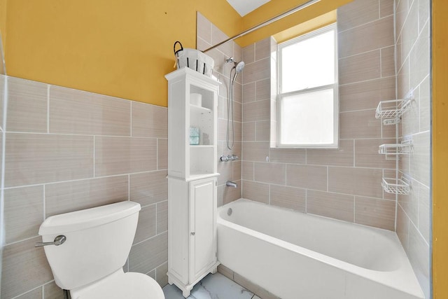 bathroom with bathtub / shower combination, marble finish floor, tile walls, and toilet