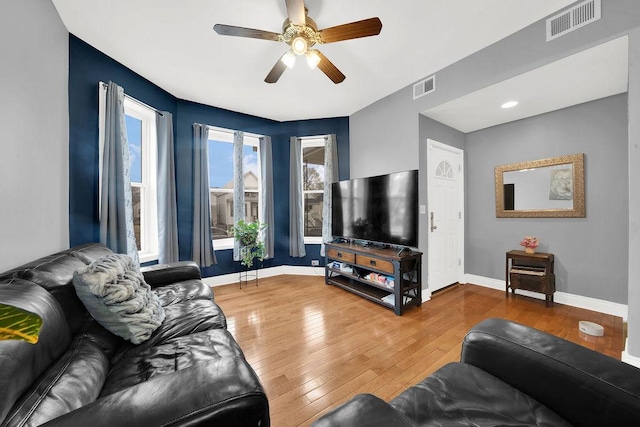 living area with visible vents, baseboards, and wood-type flooring