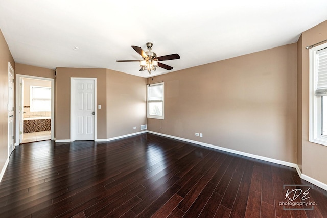 unfurnished room featuring dark wood-type flooring and ceiling fan