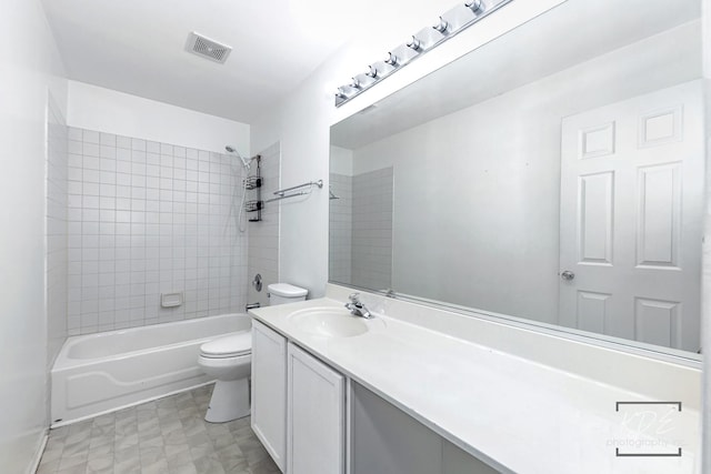 full bathroom featuring tiled shower / bath combo, vanity, and toilet