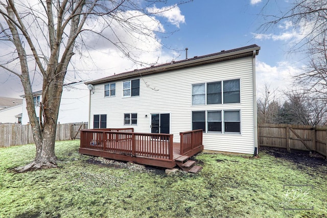 back of property featuring a deck and a lawn