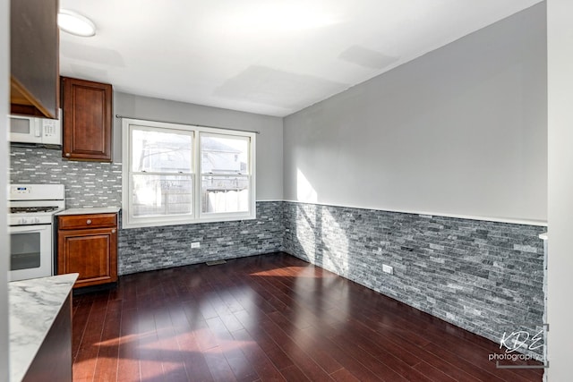 kitchen with white appliances and dark hardwood / wood-style floors