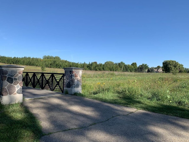 view of gate with a rural view