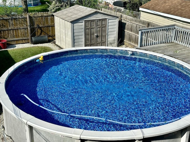 view of pool featuring a shed and a wooden deck