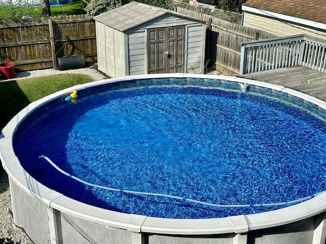 view of pool featuring a deck and a storage unit