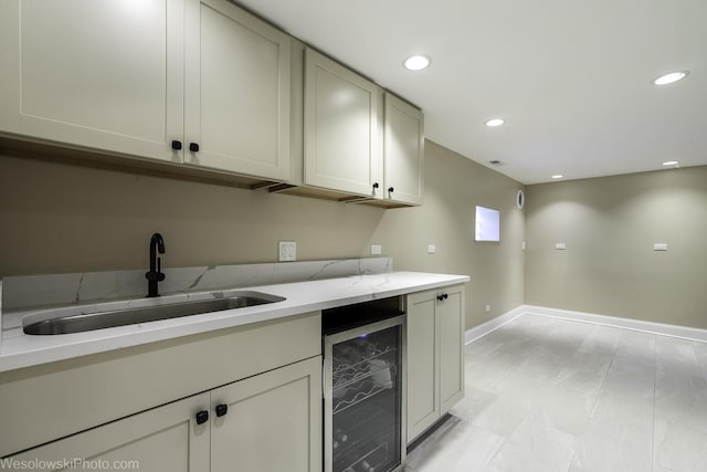 kitchen with light stone countertops, sink, and wine cooler