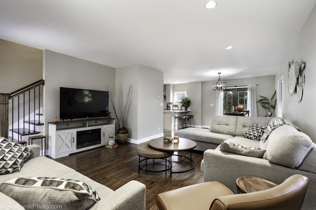 living room with a notable chandelier and dark hardwood / wood-style flooring