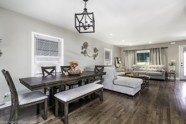 dining space featuring dark hardwood / wood-style flooring and an inviting chandelier