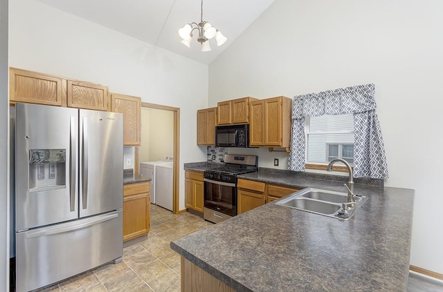 kitchen with sink, decorative light fixtures, appliances with stainless steel finishes, kitchen peninsula, and washer and clothes dryer